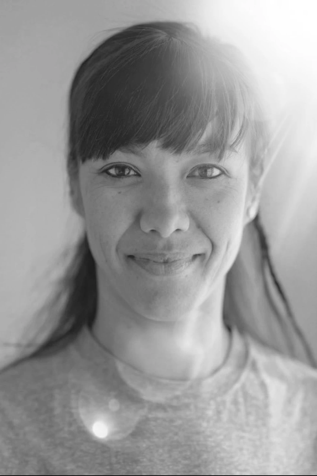 Porträt von Rebecca Weingartner mit dunklem Haar und Pony, im weichen Gegenlicht.